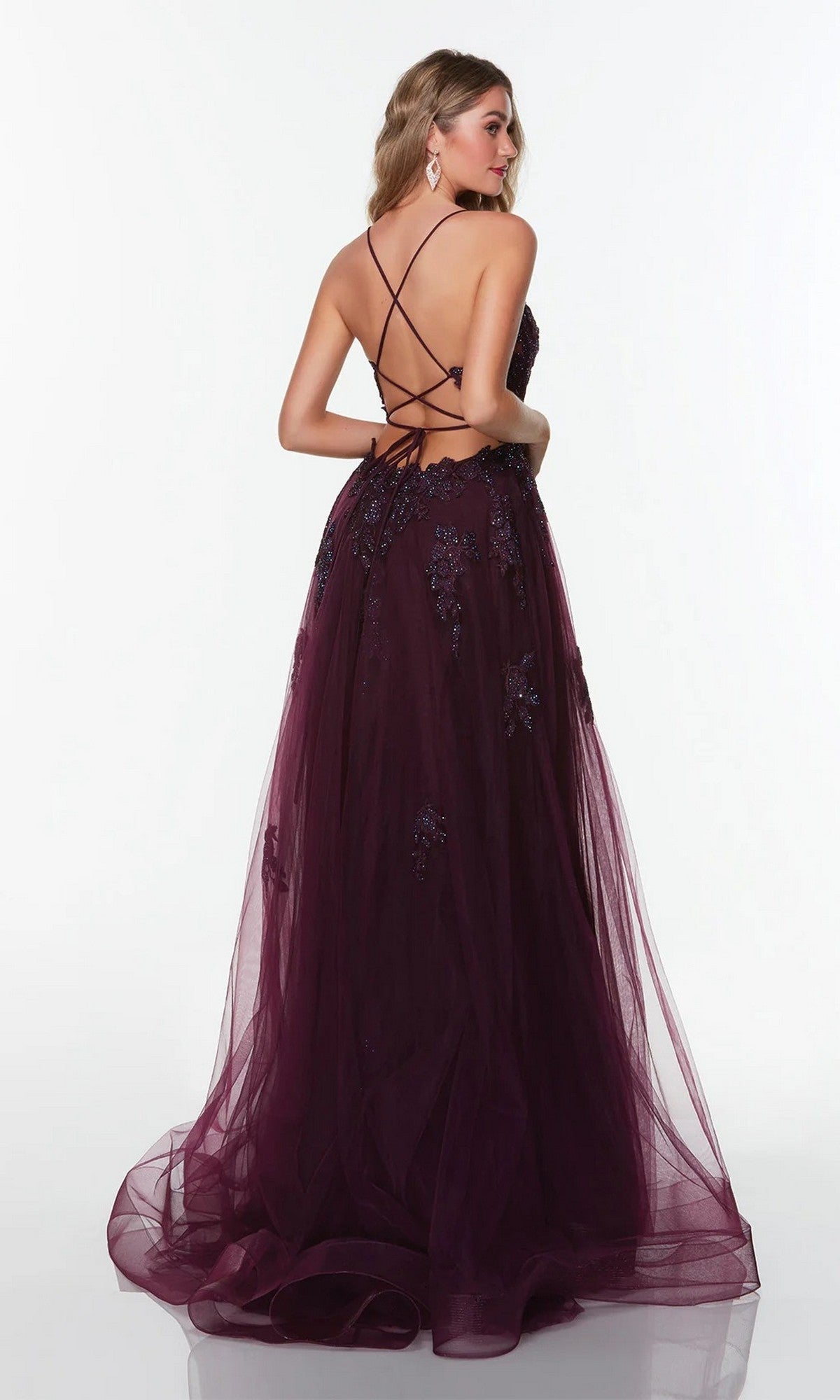 Woman in the Alyce 61263 long formal dress—floor-length, deep purple, with floral embellishments, lace appliques, and a strappy open back—stands against a plain white background.